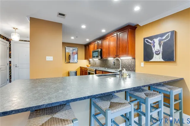 a large kitchen with stainless steel appliances a large counter top