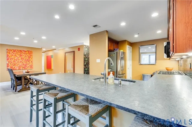 a kitchen with a table chairs sink and wooden floor