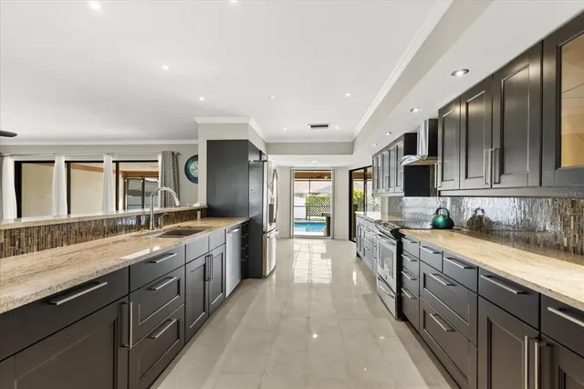a large kitchen with stainless steel appliances granite countertop a lot of counter space and wooden floors