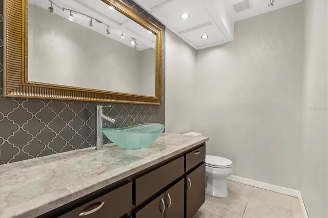 a bathroom with a granite countertop sink a toilet and mirror