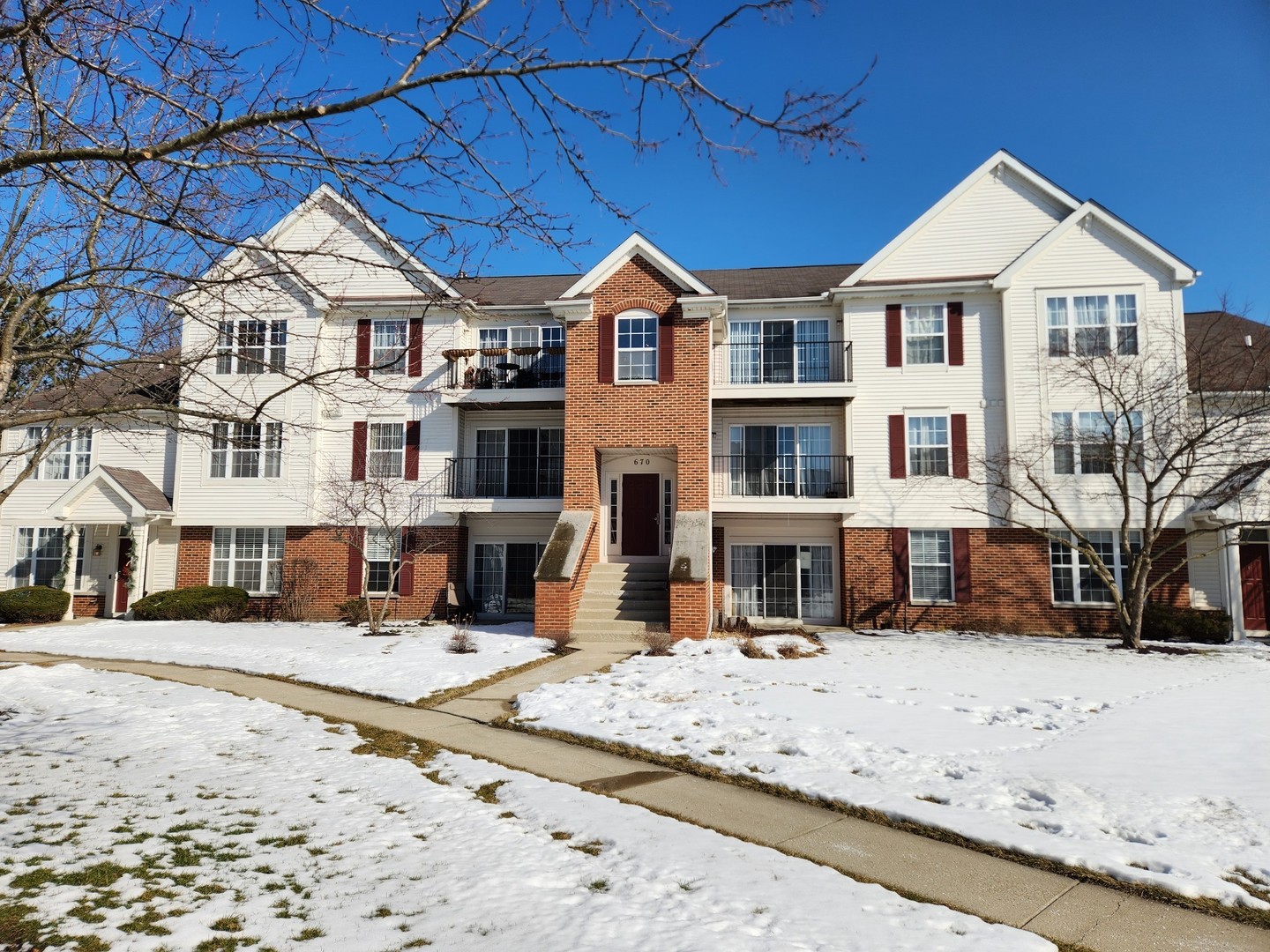 670 Mill Circle, Unit 305 Wheeling, IL 60090 - Photo 1 of 16 front view of a building with a yard covered in snow
