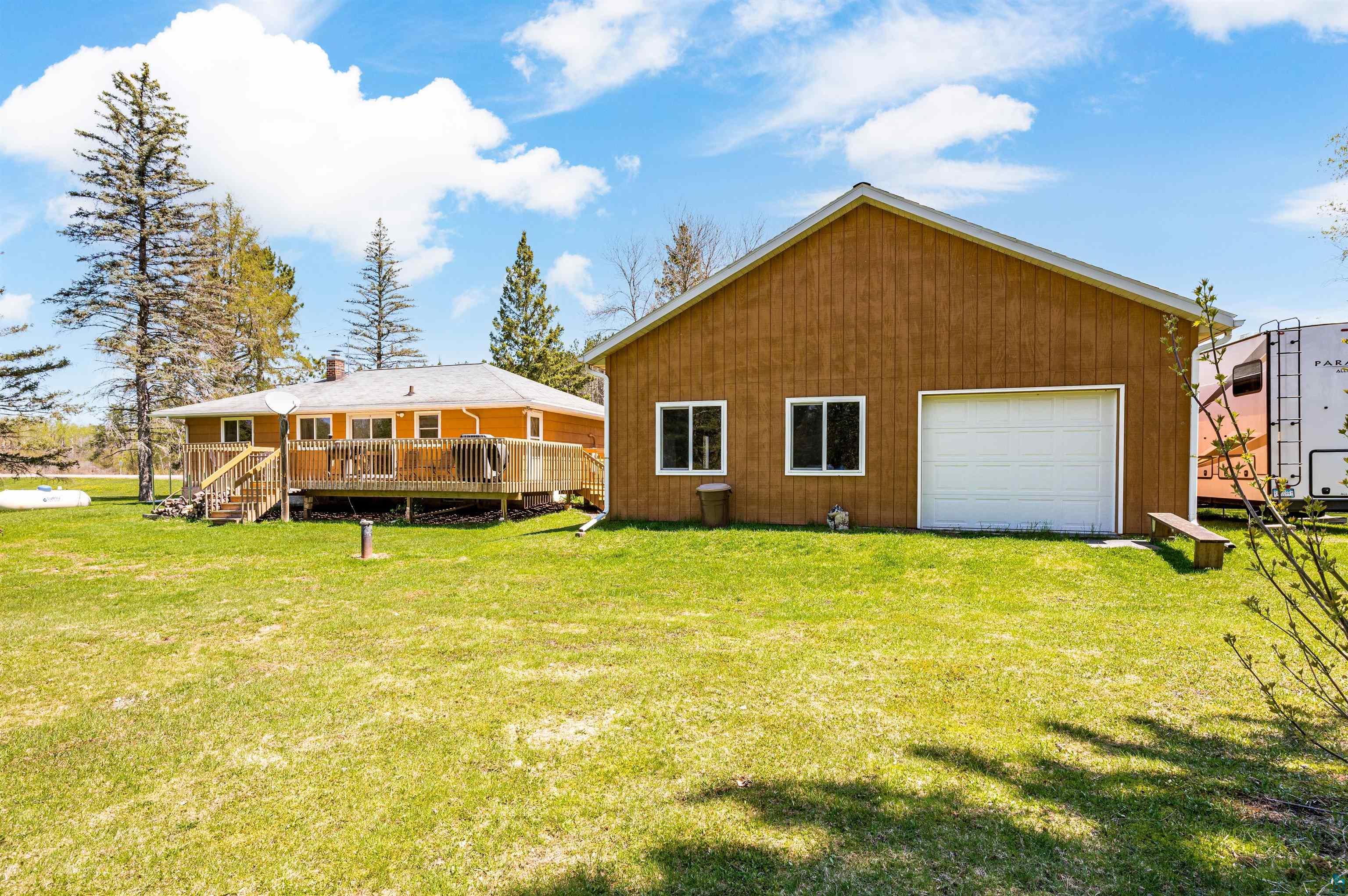 4387 Midway Road Hermantown, MN 55811 - Photo 5 of 35 Rear view of house with a garage, a lawn, and a wooden deck