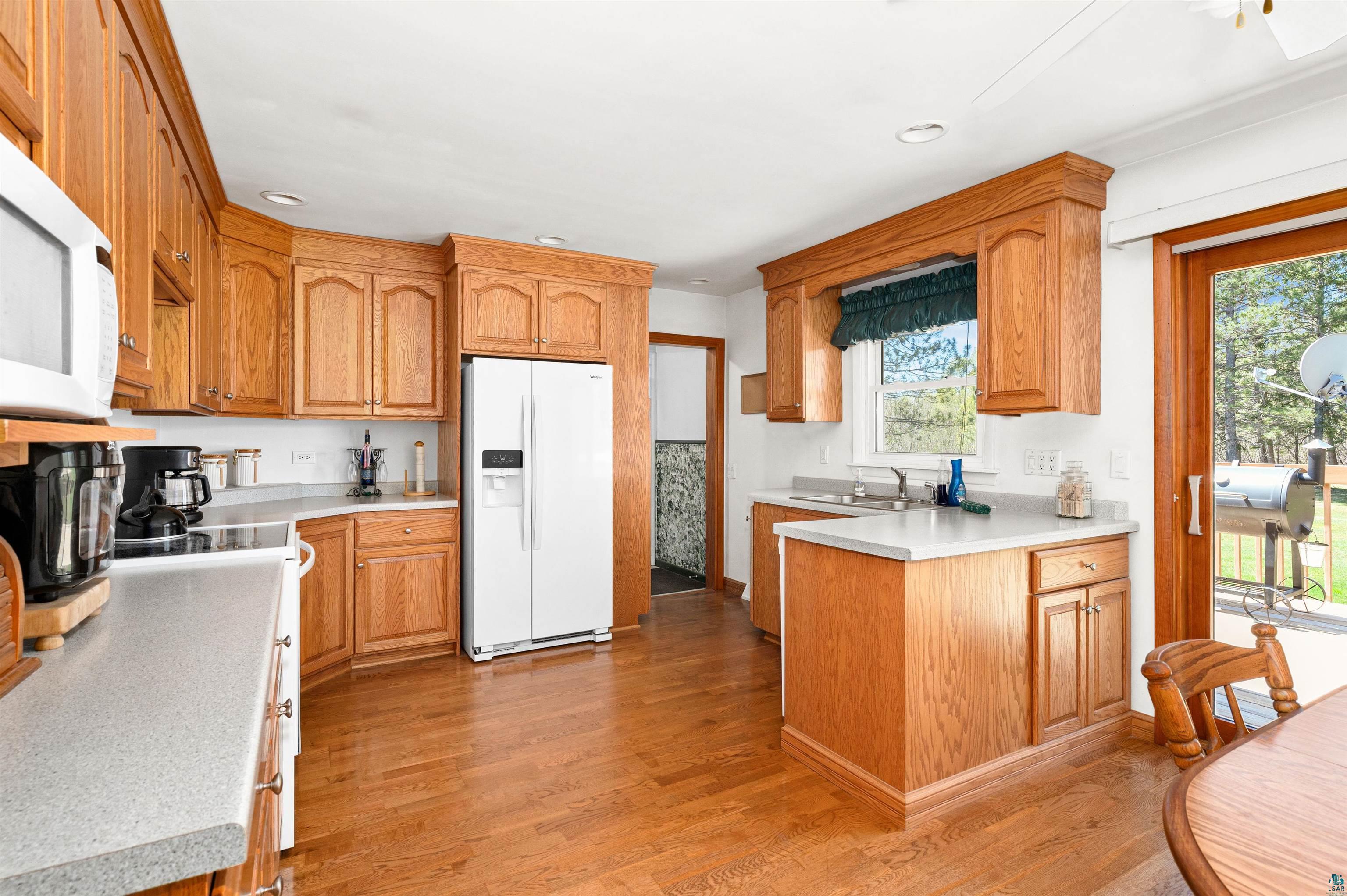 4387 Midway Road Hermantown, MN 55811 - Photo 8 of 35 Kitchen featuring a healthy amount of sunlight, light hardwood / wood-style flooring, white appliances, and sink