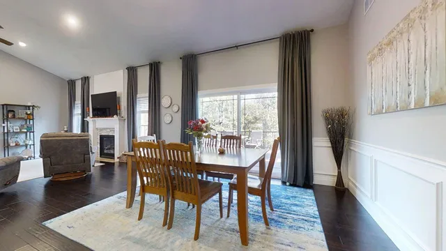 a large kitchen with cabinets chairs and wooden floor