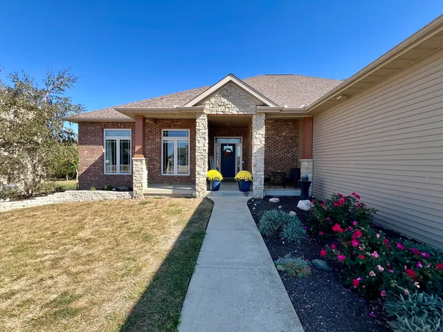 a view of a house with large windows and potted plants