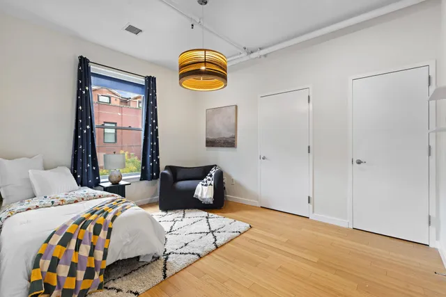 a bedroom with a bed and wooden floor