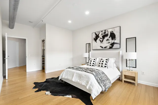 a bedroom with a bed and a wooden floor