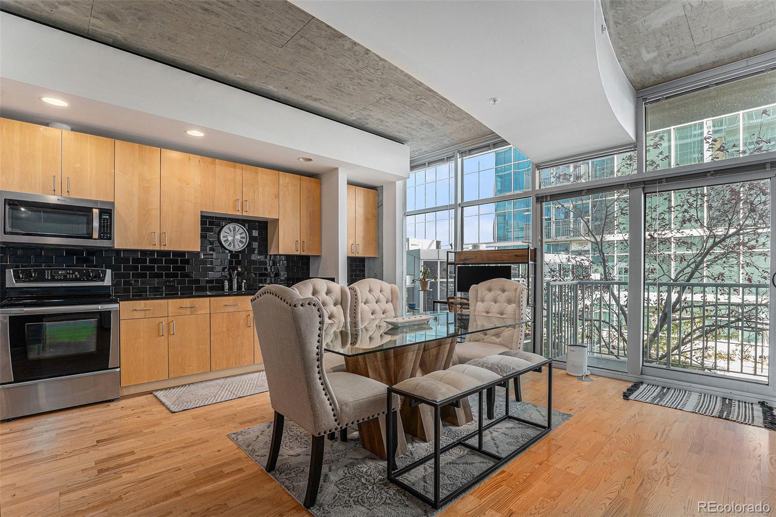 1700 Bassett Street, Unit 903 Denver, CO 80202 - Photo 11 of 31 a kitchen with stainless steel appliances granite countertop a stove a refrigerator a kitchen island a table and chairs