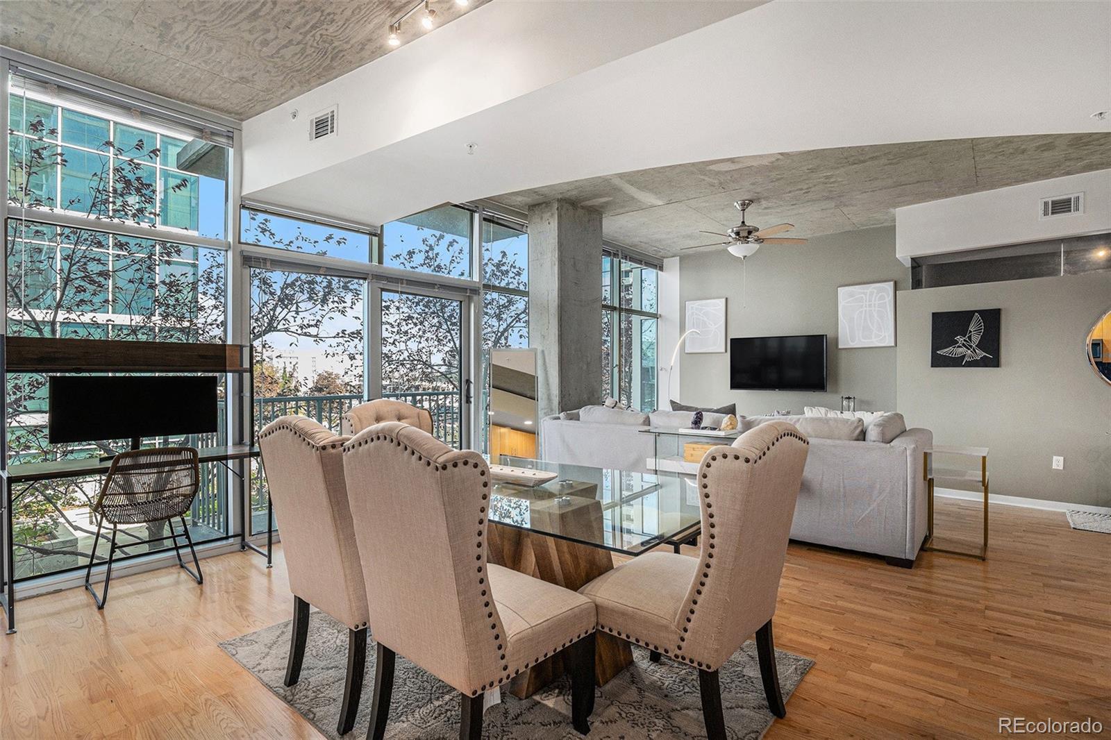 1700 Bassett Street, Unit 903 Denver, CO 80202 - Photo 12 of 31 a living room with furniture a flat screen tv and a floor to ceiling window