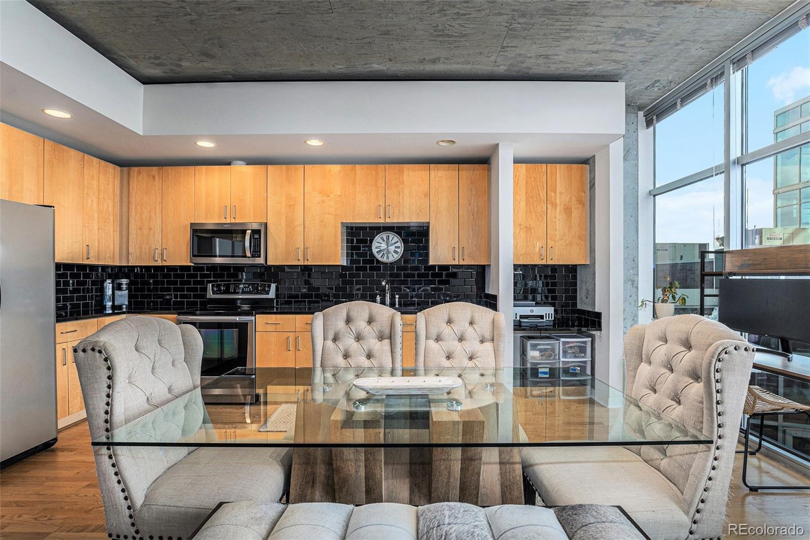 1700 Bassett Street, Unit 903 Denver, CO 80202 - Photo 14 of 31 a kitchen with stainless steel appliances wooden floor dining table and chairs