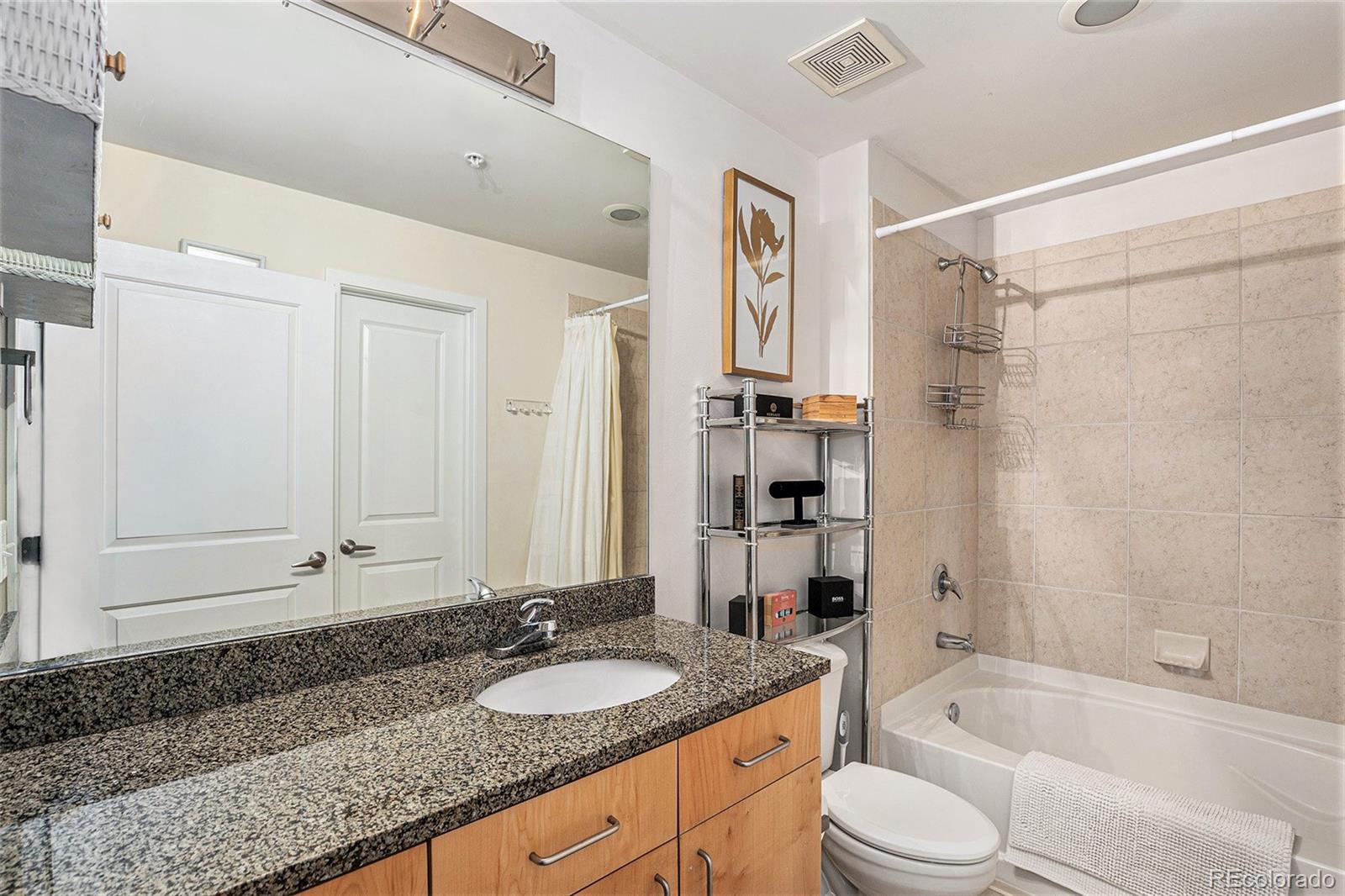 1700 Bassett Street, Unit 903 Denver, CO 80202 - Photo 18 of 31 a bathroom with a granite countertop tub sink and mirror