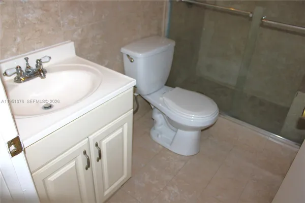 a white toilet sitting next to a white sink