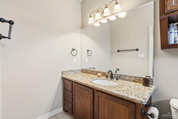 1405 Eva Street Edinburg, TX 78539 - Photo 12 of 18 a bathroom with a granite countertop sink a mirror and vanity