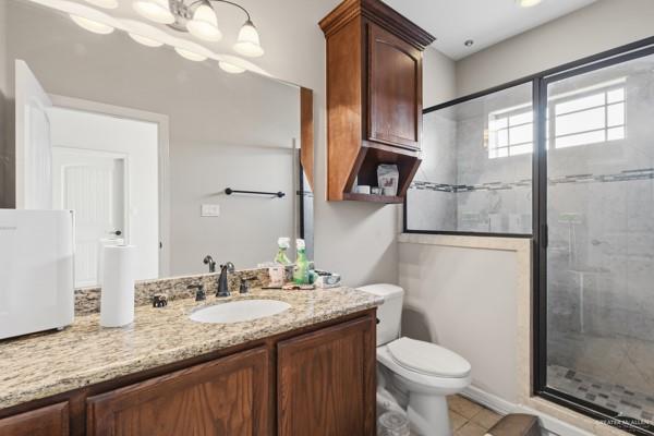 1405 Eva Street Edinburg, TX 78539 - Photo 14 of 18 a bathroom with a granite countertop sink toilet and shower