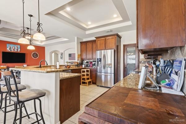 1405 Eva Street Edinburg, TX 78539 - Photo 5 of 18 a kitchen with stainless steel appliances granite countertop a refrigerator a stove a sink dishwasher and a dining table with the kitchen view
