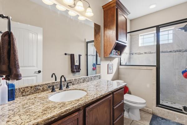 1405 Eva Street Edinburg, TX 78539 - Photo 10 of 18 a bathroom with a granite countertop sink toilet and a mirror