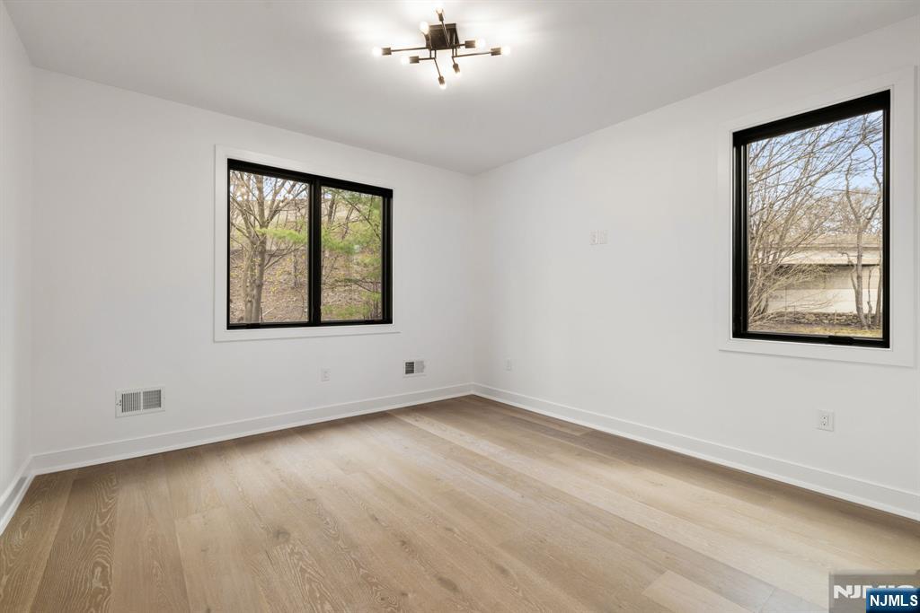 45 Riverview Terrace Mahwah, NJ 07430 - Photo 16 of 25 a view of an empty room with a window and wooden floor