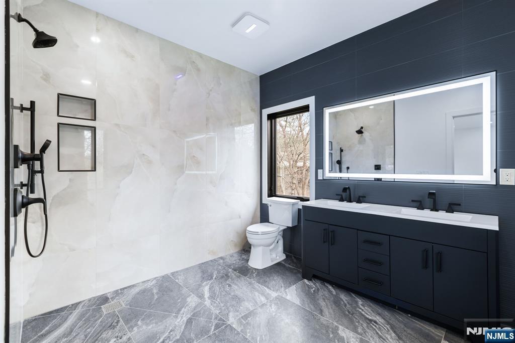 45 Riverview Terrace Mahwah, NJ 07430 - Photo 19 of 25 a spacious bathroom with a double vanity sink toilet and shower