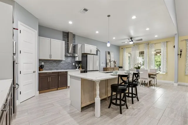 a kitchen with kitchen island granite countertop wooden floors and white cabinets
