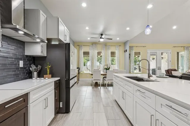 a large kitchen with stainless steel appliances kitchen island granite countertop a large counter top a stove and a sink