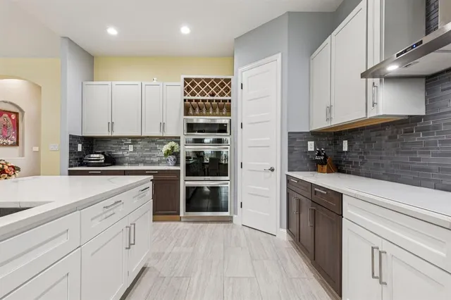 a kitchen with stainless steel appliances granite countertop a stove a sink and a refrigerator