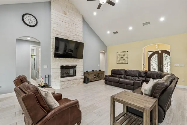 a living room with furniture a flat screen tv and a fireplace