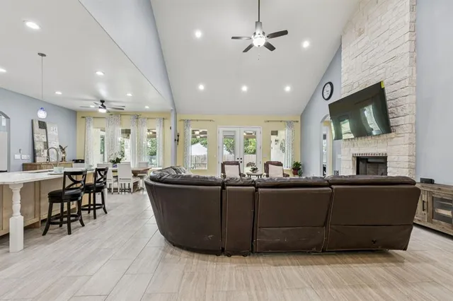 a living room with furniture a flat screen tv and kitchen view