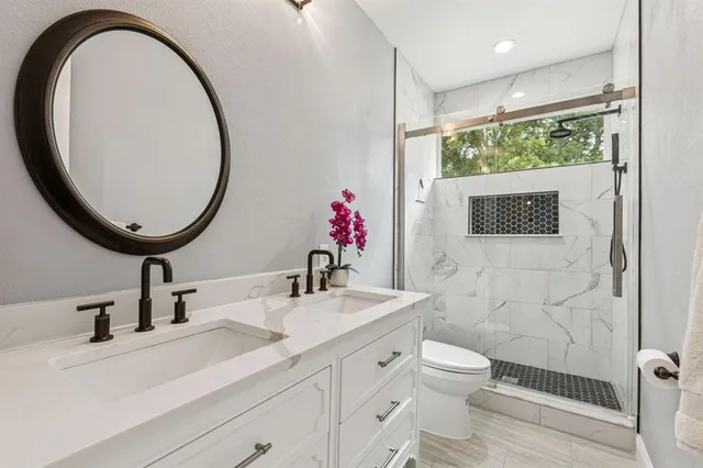 a bathroom with a sink a toilet and a mirror