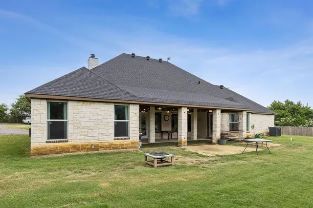 a backyard of a house with yard table and chairs