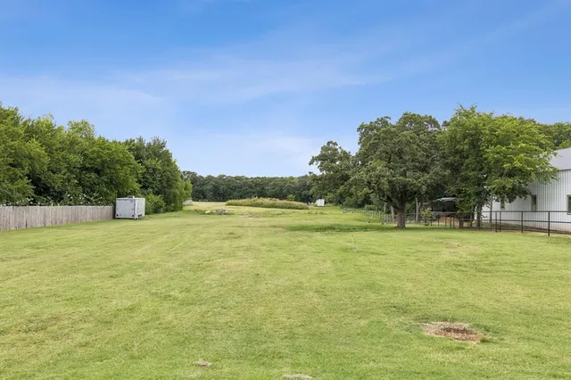 a view of a field with trees in the background