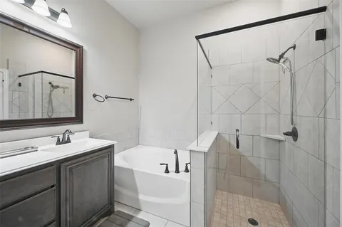 a bathroom with a bathtub shower sink vanity and toilet