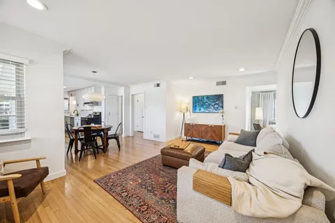 a living room with furniture a dining table and a piano next to a window