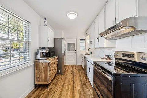 a kitchen with granite countertop a sink a counter space stainless steel appliances and cabinets