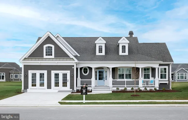 a front view of a house with a garden and trees