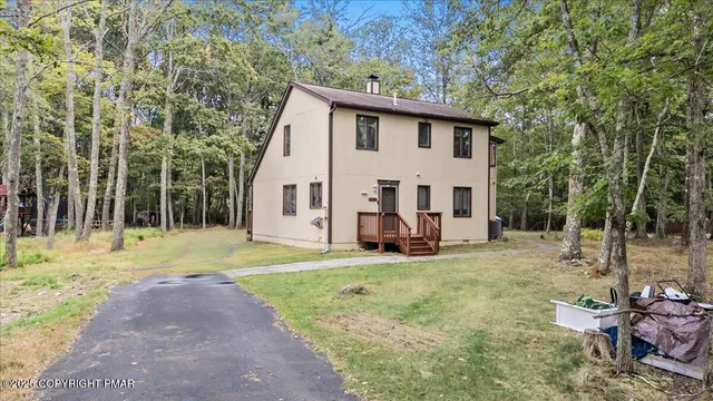 a view of a house with backyard and trees