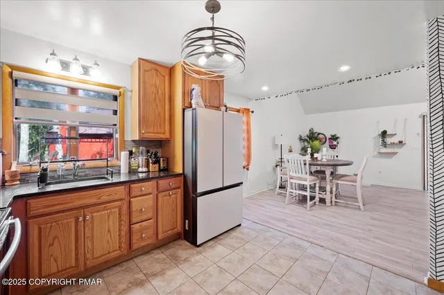 a dining hall with stainless steel appliances granite countertop a refrigerator and a stove top oven