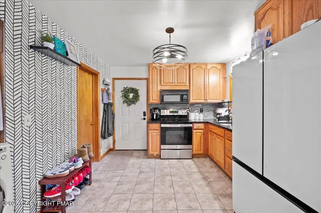 a kitchen with stainless steel appliances granite countertop a refrigerator and microwave