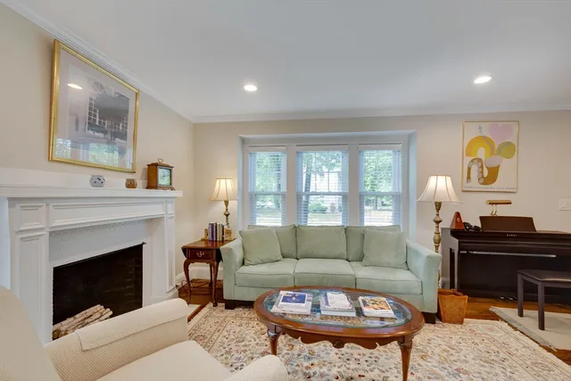 a living room with furniture a fireplace and a large window