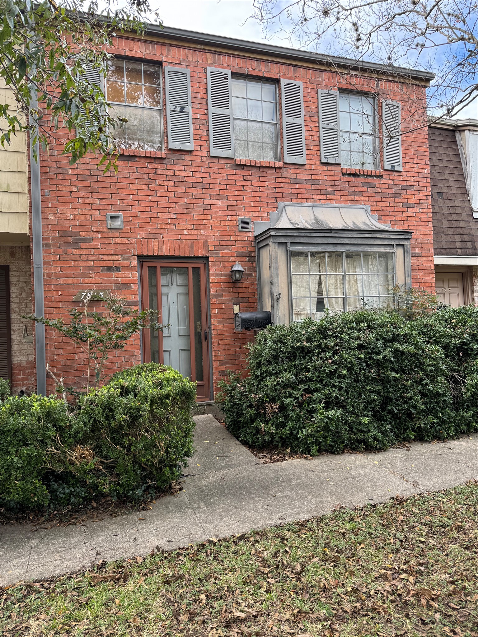 front view of a brick house with a yard