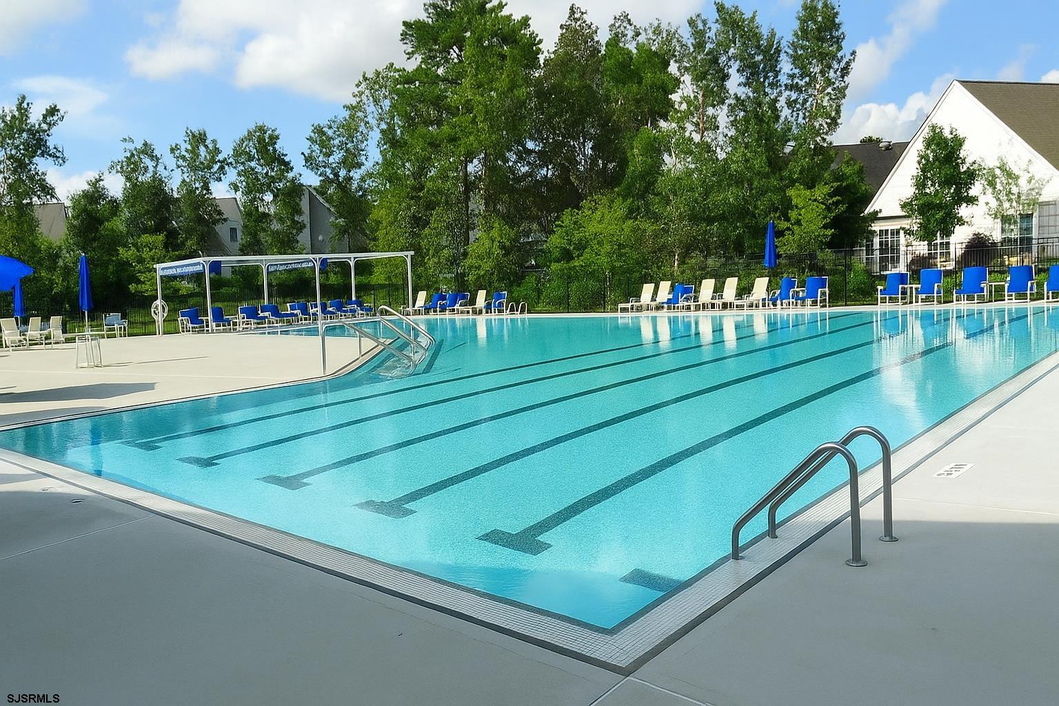 243 Lily Road Egg Harbor Township, NJ 08234 - Photo 23 of 29 a view of a swimming pool with a bench and trees in the background