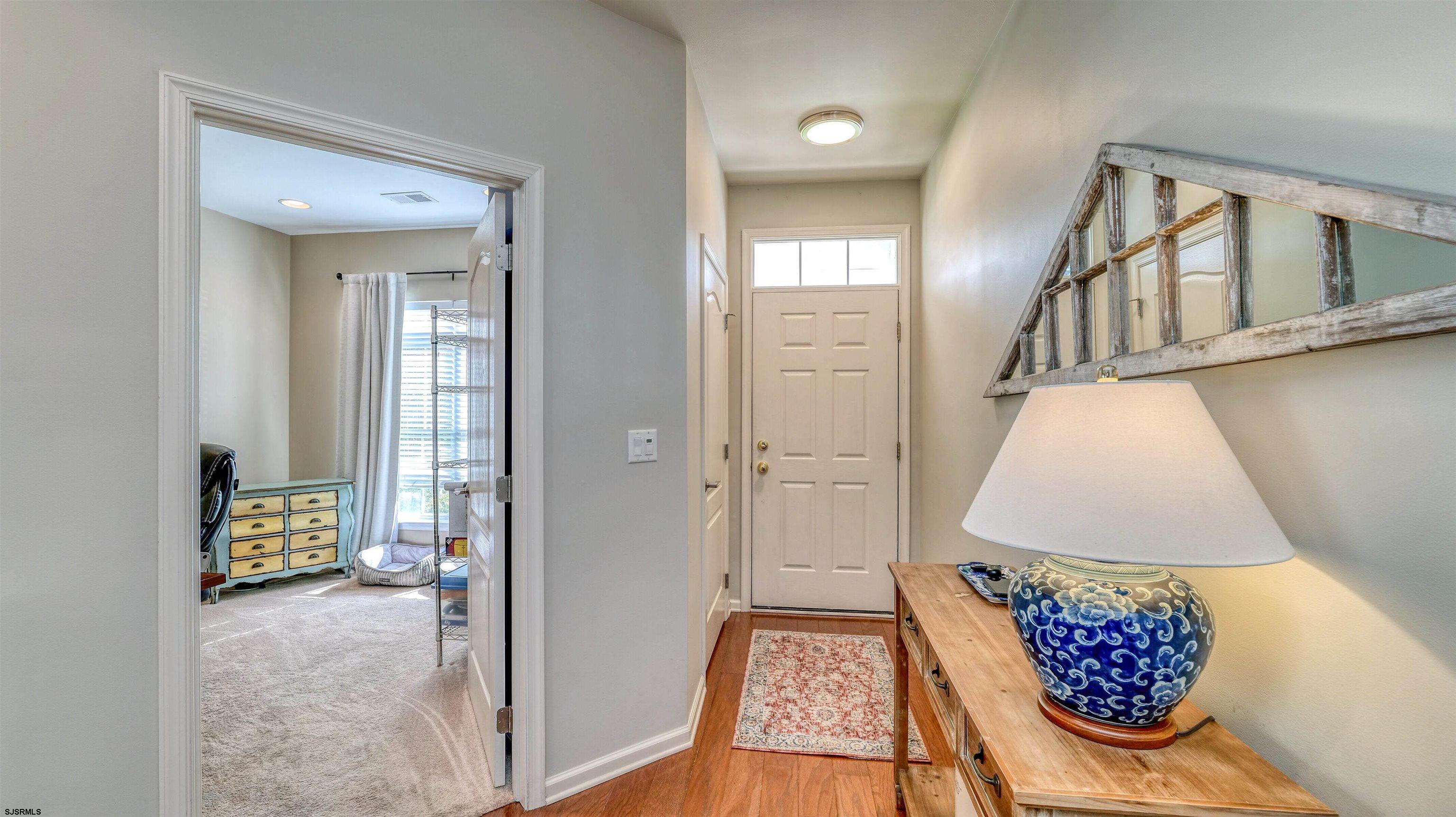 243 Lily Road Egg Harbor Township, NJ 08234 - Photo 4 of 29 wooden floor with windows and a table in a room