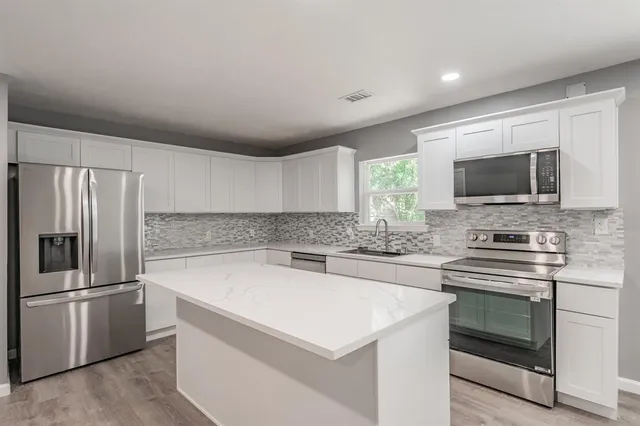 a kitchen with stainless steel appliances a stove microwave and refrigerator