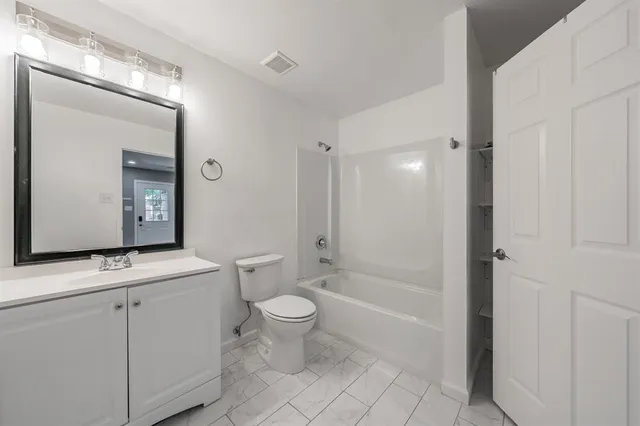 a bathroom with a toilet a sink and mirror