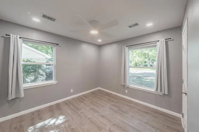 an empty room with windows and closet