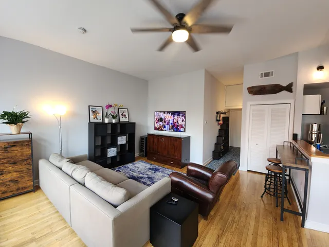 a living room with furniture and a wooden floor