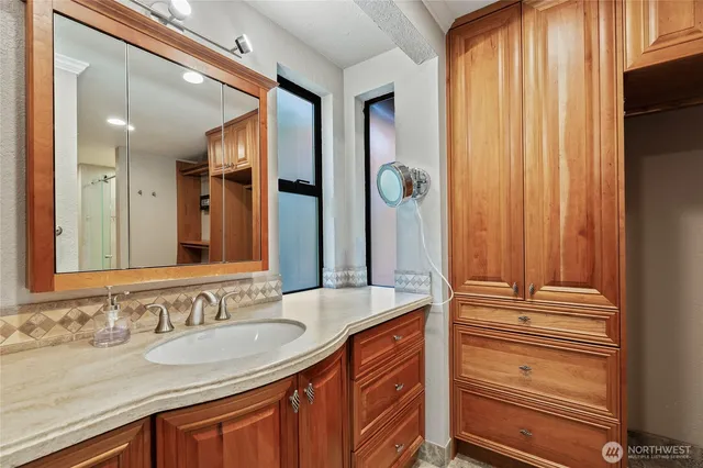 a bathroom with a granite countertop sink and a mirror