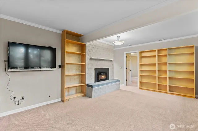 a view of an empty room with a fireplace and cabinet