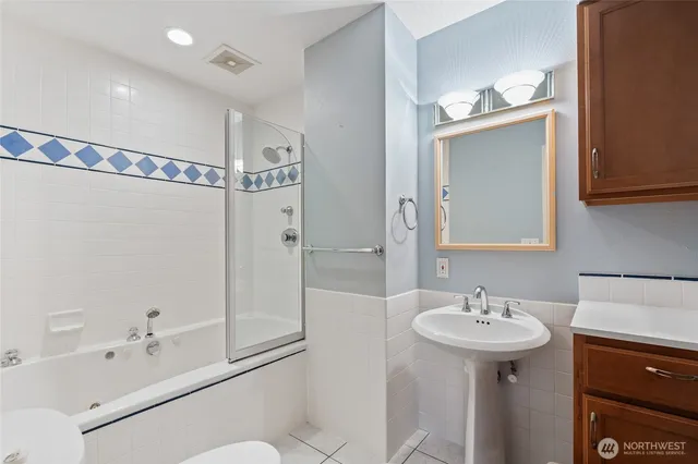 a bathroom with a shower sink vanity and mirror