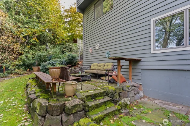 a view of backyard with outdoor seating and plants