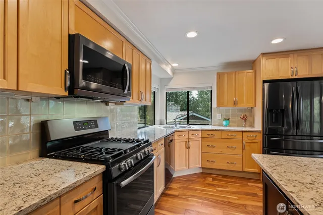 a kitchen with stainless steel appliances granite countertop a stove and a microwave